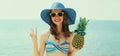 Portrait happy smiling young woman on a beach with funny pineapple wearing a straw hat Royalty Free Stock Photo