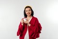 Portrait of a happy smiling young woman in cozy red sweater holding cup of coffee, standing over white background Royalty Free Stock Photo