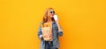 Portrait of happy smiling young woman holding grocery shopping paper bag with long white bread baguette and cup of coffee on Royalty Free Stock Photo