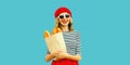 Portrait of happy smiling young woman holding grocery shopping paper bag with long white loaf bread baguette wearing french red