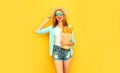 Portrait happy smiling young woman holding paper bag with long white bread baguette, wearing straw hat, shorts on colorful yellow Royalty Free Stock Photo