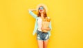 portrait happy smiling young woman holding paper bag with long white bread baguette, wearing straw hat, shorts on colorful yellow Royalty Free Stock Photo