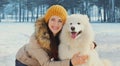 Portrait of happy smiling young woman owner with her white Samoyed dog in winter Royalty Free Stock Photo