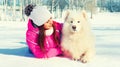 Portrait of happy smiling young woman owner with her white Samoyed dog in winter park Royalty Free Stock Photo