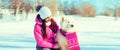 Portrait of happy smiling young woman owner with her white Samoyed dog in winter park Royalty Free Stock Photo