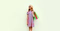 Portrait of happy smiling young woman with shopping bags wearing summer colorful dress on white background Royalty Free Stock Photo