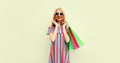 Portrait of happy smiling young woman with shopping bags wearing summer colorful dress on white background Royalty Free Stock Photo