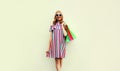 Portrait of happy smiling young woman with shopping bags wearing summer colorful dress on white background Royalty Free Stock Photo