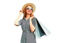 Portrait of happy smiling young woman with shopping bags wearing summer straw round hat, black white striped dress isolated on Royalty Free Stock Photo