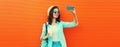 Portrait of happy smiling young woman taking selfie with smartphone with cup of coffee wearing summer straw hat, backpack on Royalty Free Stock Photo