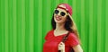 Portrait happy smiling young woman wearing a red baseball cap and backpack in a city Royalty Free Stock Photo