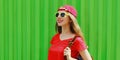 Portrait happy smiling young woman wearing a red baseball cap and backpack in a city Royalty Free Stock Photo