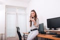 Casual young woman texting on phone in her office Royalty Free Stock Photo