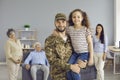 Portrait of happy soldier dad who has come back home holding his little daughter Royalty Free Stock Photo