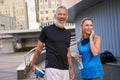 Portrait of happy sportive middle aged couple, man and woman in sportswear smiling, standing together outdoors ready for Royalty Free Stock Photo