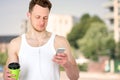 Portrait of a happy sports man standing near sport field with a mobile phone outdoors Royalty Free Stock Photo