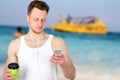 Portrait of a happy sports man standing near sport field with a mobile phone outdoors Royalty Free Stock Photo