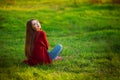 Portrait of happy sporty woman relaxing in park on green meadow. Joyful female model breathing fresh air outdoors Royalty Free Stock Photo