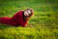 Portrait of happy sporty woman relaxing in park on green meadow. Joyful female model breathing fresh air outdoors Royalty Free Stock Photo