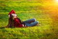 Portrait of happy sporty woman relaxing in park on green meadow. Joyful female model breathing fresh air outdoors Royalty Free Stock Photo