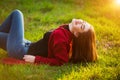 Portrait of happy sporty woman relaxing in park on green meadow. Joyful female model breathing fresh air outdoors Royalty Free Stock Photo