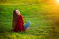 Portrait of happy sporty woman relaxing in park on green meadow. Joyful female model breathing fresh air outdoors Royalty Free Stock Photo