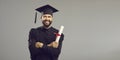 Portrait of a happy student in an academic dress and hat having a university or academy certificate. Royalty Free Stock Photo