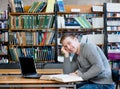 Portrait of a happy student with laptop in the university library