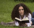 Portrait of happy student relaxed outdoors reading Royalty Free Stock Photo