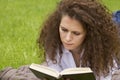 Portrait of happy student relaxed outdoors reading Royalty Free Stock Photo