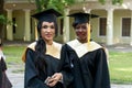 Portrait of happy students in graduation gowns Royalty Free Stock Photo