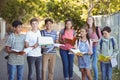 Portrait of happy students standing with books on road Royalty Free Stock Photo