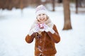 Happy child showing heart hands outdoors in city park in winter Royalty Free Stock Photo