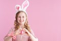 Portrait of happy stylish child in pink dress on pink