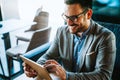 Portrait of happy succeffsul young business man, leader, ceo, manager using digital tablet to work. Royalty Free Stock Photo