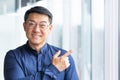 Portrait of happy and successful asian businessman, man smiling and looking at camera pointing with finger towards Royalty Free Stock Photo