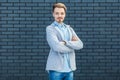 Portrait of happy successful handsome young blonde man in casual style standing with crossed arms and looking at camera with smile Royalty Free Stock Photo