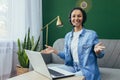 Portrait of happy and successful hispanic woman at home, businesswoman with video headset smiling and looking at camera Royalty Free Stock Photo