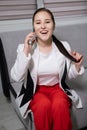 portrait of happy, surprised, excited brunette business woman talking by phone in gray office. gain, good phone call Royalty Free Stock Photo