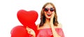 Portrait of happy surprised laughing young woman with red heart shaped balloons wearing sunglasses isolated on white background Royalty Free Stock Photo