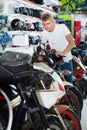 Portrait of male motorcyclist looking on the bike in the store