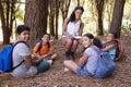 Portrait of happy teacher and students sitting in forest Royalty Free Stock Photo