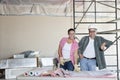 Portrait of happy team of architects with building plans at construction site Royalty Free Stock Photo