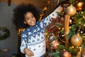 Portrait of happy teen biracial kid decorate fir tree