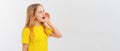 Portrait of happy teen girl holding palm near wide open mouth calling someone yelling information announcement loudly, stands in