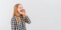 Portrait of happy teen girl holding palm near wide open mouth calling someone yelling information announcement loudly, stands over