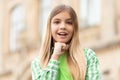Portrait of happy teen girl smiling with chin on hand blurry outdoors Royalty Free Stock Photo