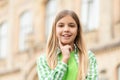 Portrait of happy teen girl smiling with finger on cheek blurry outdoors Royalty Free Stock Photo