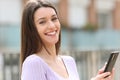 Happy teen holding phone looking at camera Royalty Free Stock Photo