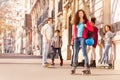 Happy teenage girl rollerblading with friends Royalty Free Stock Photo